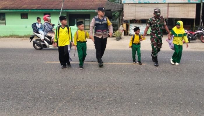Kekompakan Bhabinkamtibmas Polsek Peureulak dan Babinsa Saat Memberi Pelayanan Kepada Anak Sekolah