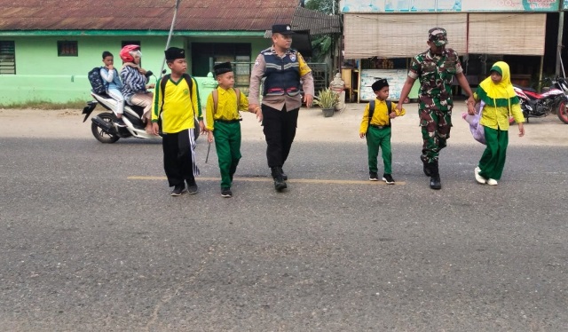 Kekompakan Bhabinkamtibmas Polsek Peureulak dan Babinsa Saat Memberi Pelayanan Kepada Anak Sekolah