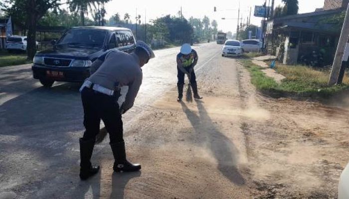 Peduli Keselamatan Pengendara, Anggota Satlantas Polres Aceh Timur Bersihkan Material Kerikil di Jalan