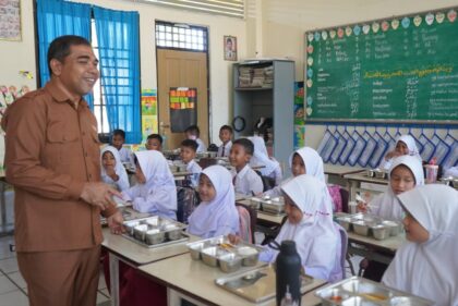 Foto : Pelaksana Tugas (Plt) Sekretaris Daerah Abdya, Amrizal, S.Sos., turun langsung meninjau pembagian makanan bergizi untuk 200 siswa di SD Negeri Tunas Bangsa, Senin (13/10/2025).