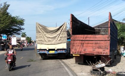 Truk antrian untuk isi BBM parkir di badan jalan.