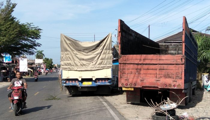 Truk antrian untuk isi BBM parkir di badan jalan.